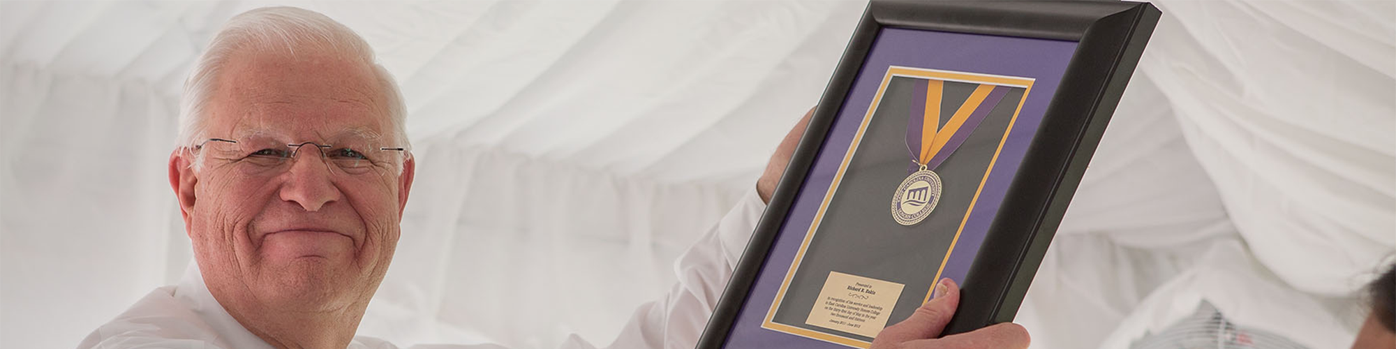 Photo of Dr. Richard Eakin receiving the first-ever Honors College medallion