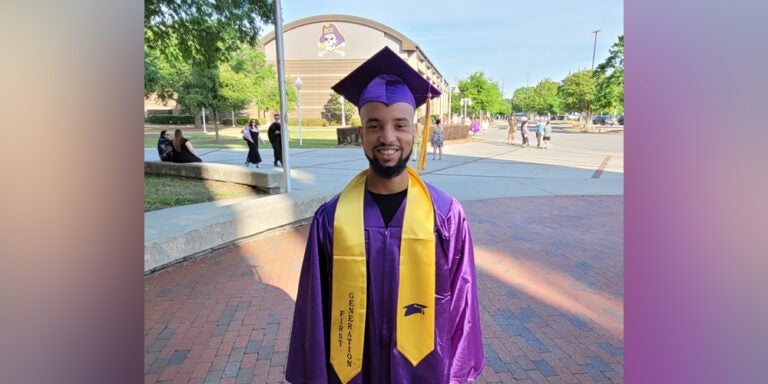 Student in ECU purple graduation robe